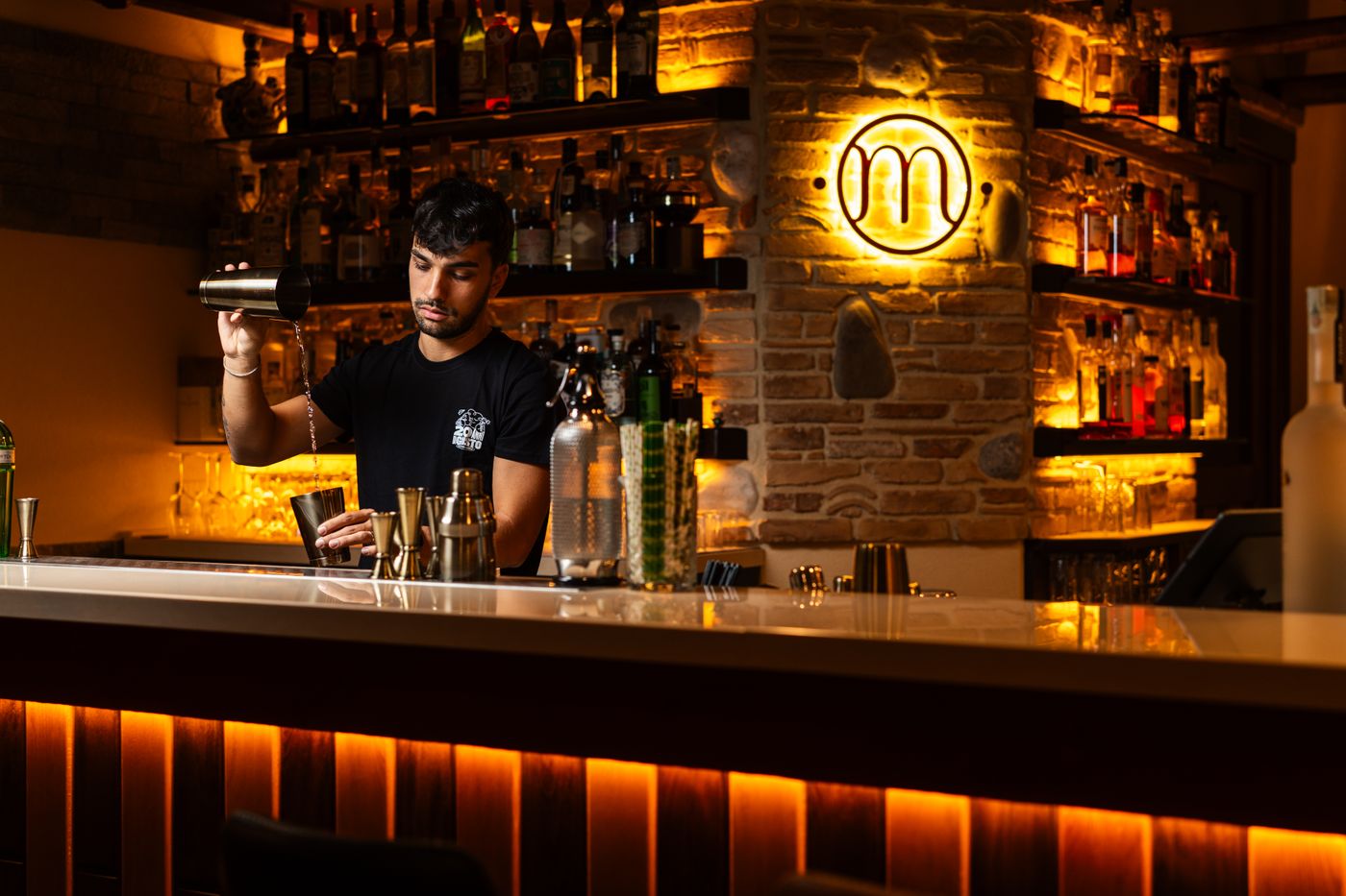 Bartender mixing drinks in the dim bar