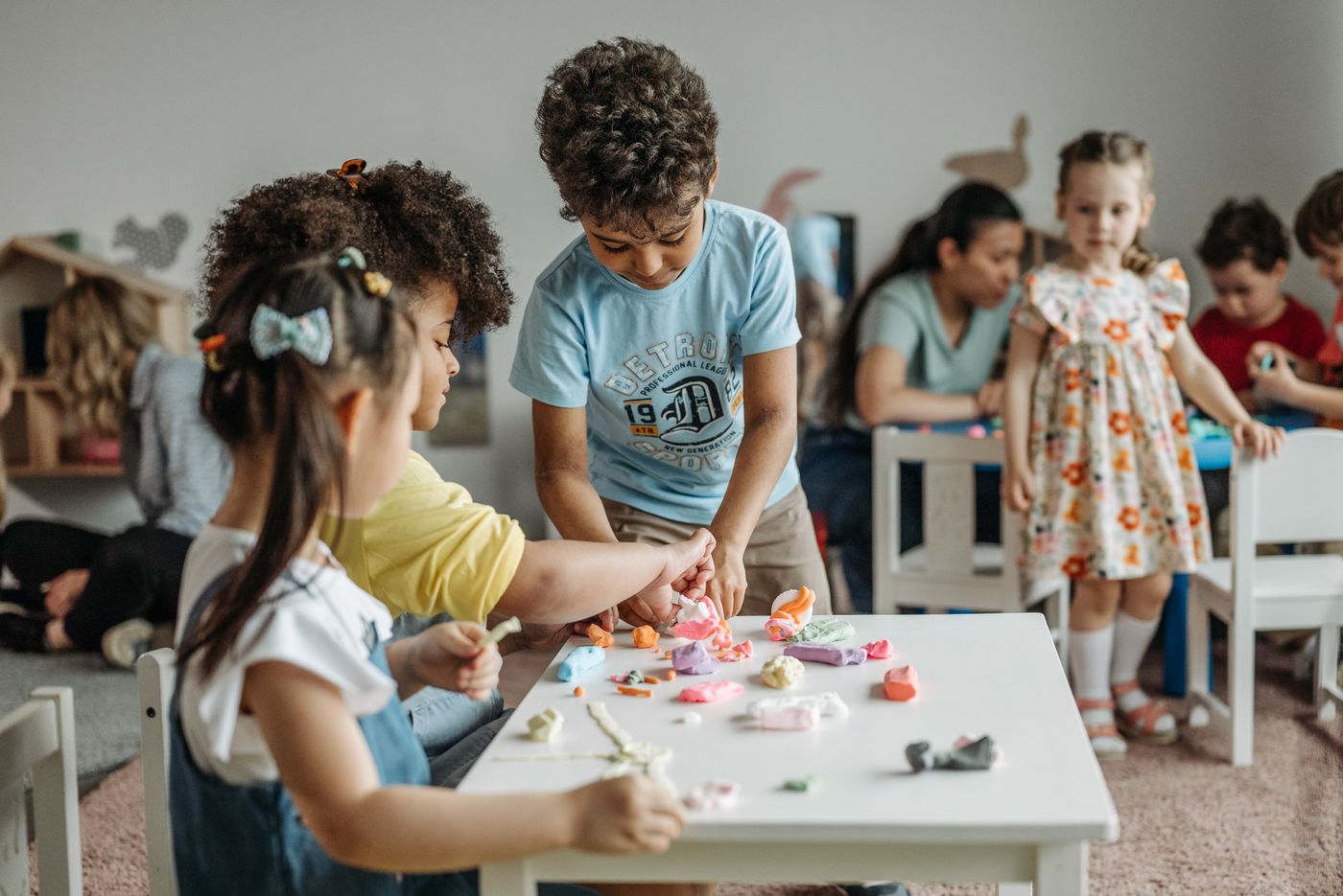 Kids doing colorful craft projects at a low table