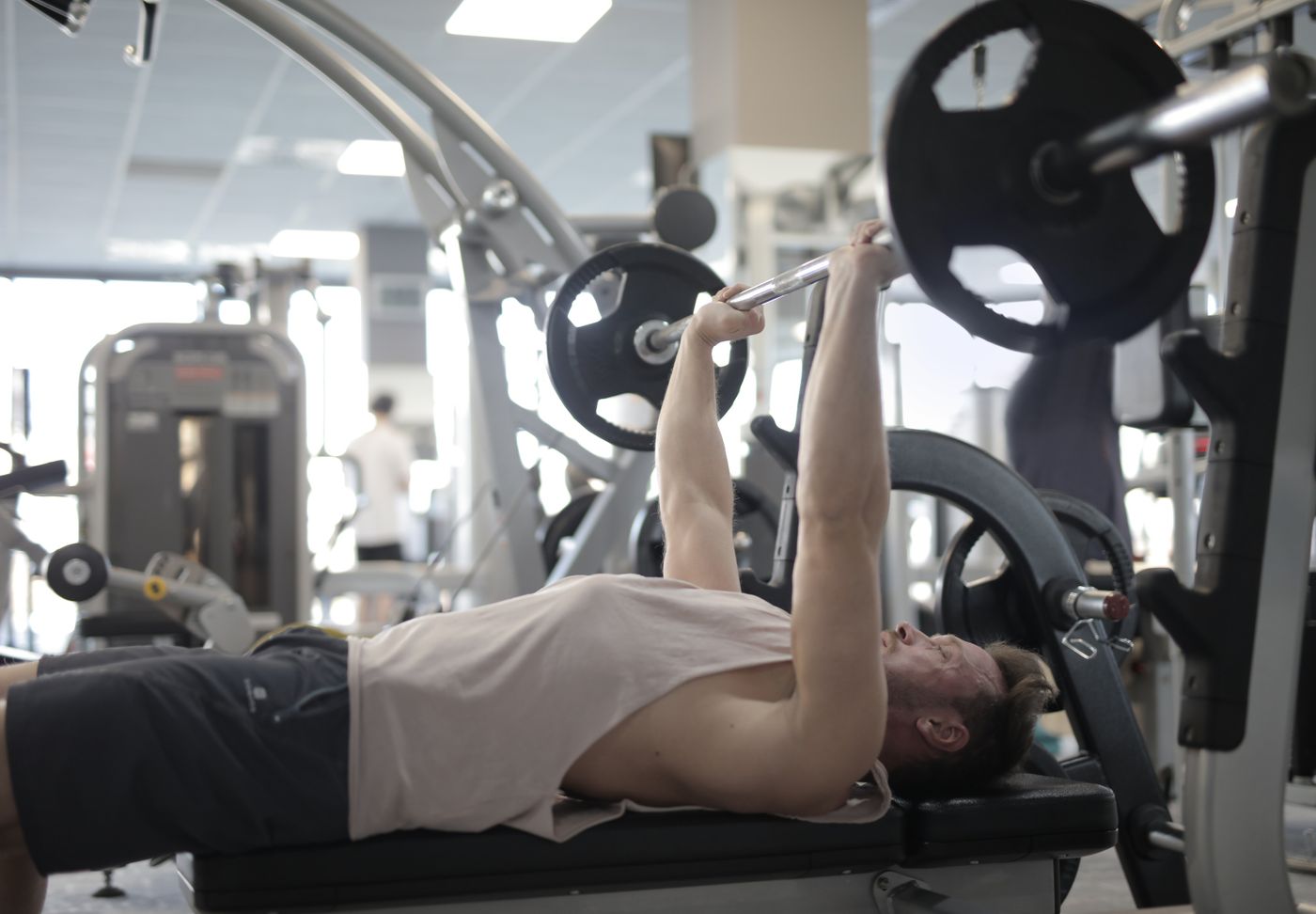 Athlete training with a barbell under gym lights