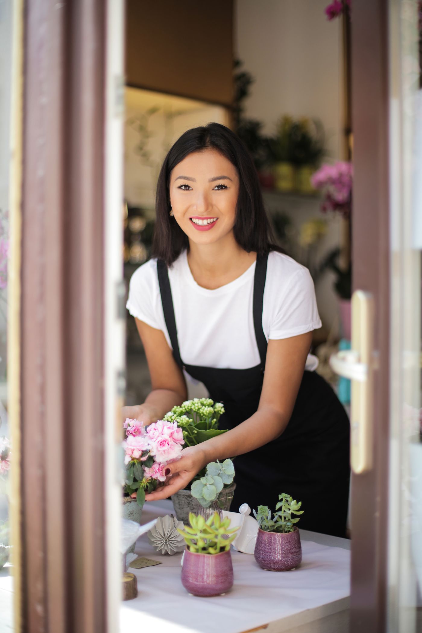 Florist arranging stems at a wooden workbench