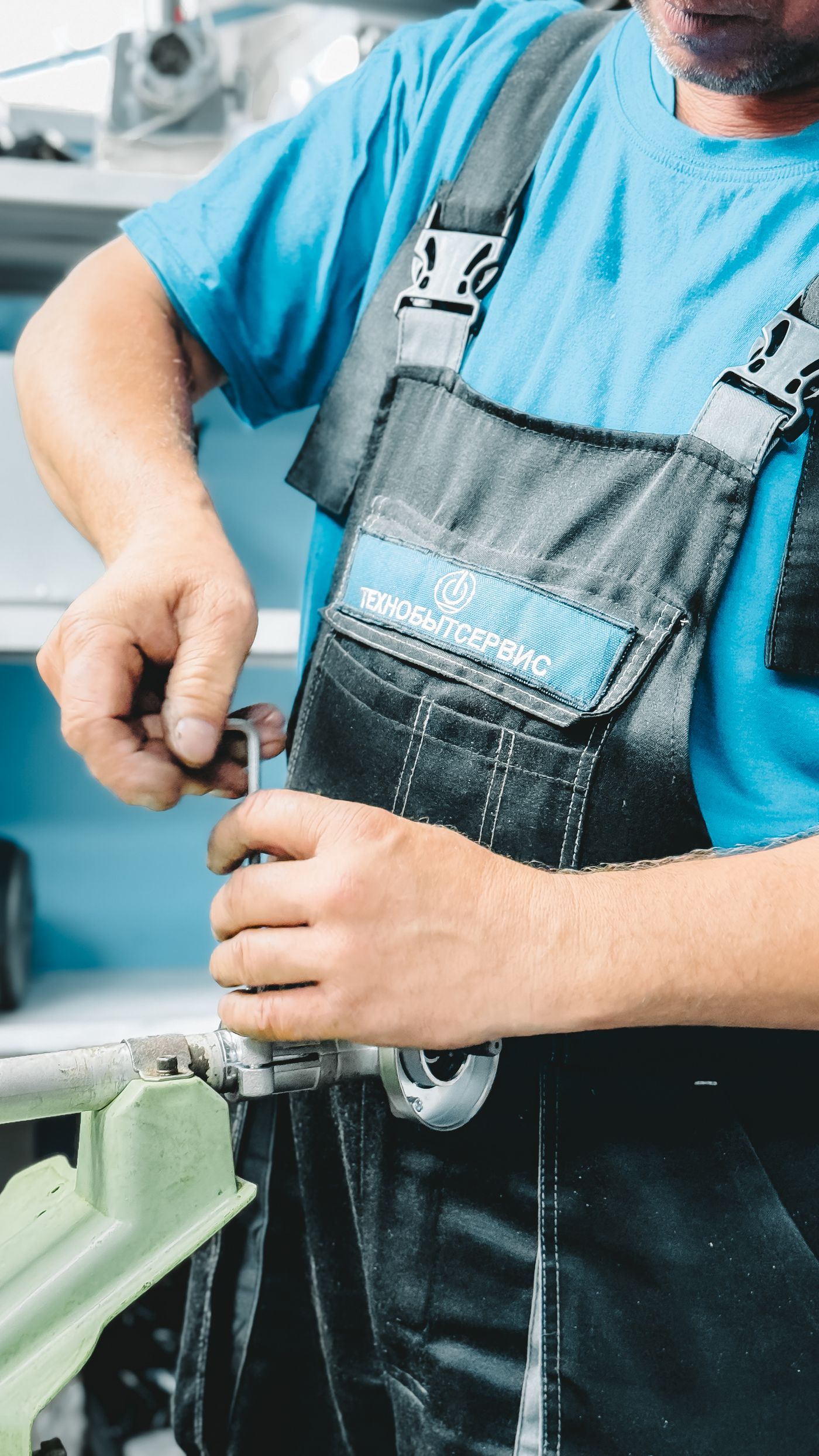 Technician in branded workwear fixing a kitchen sink