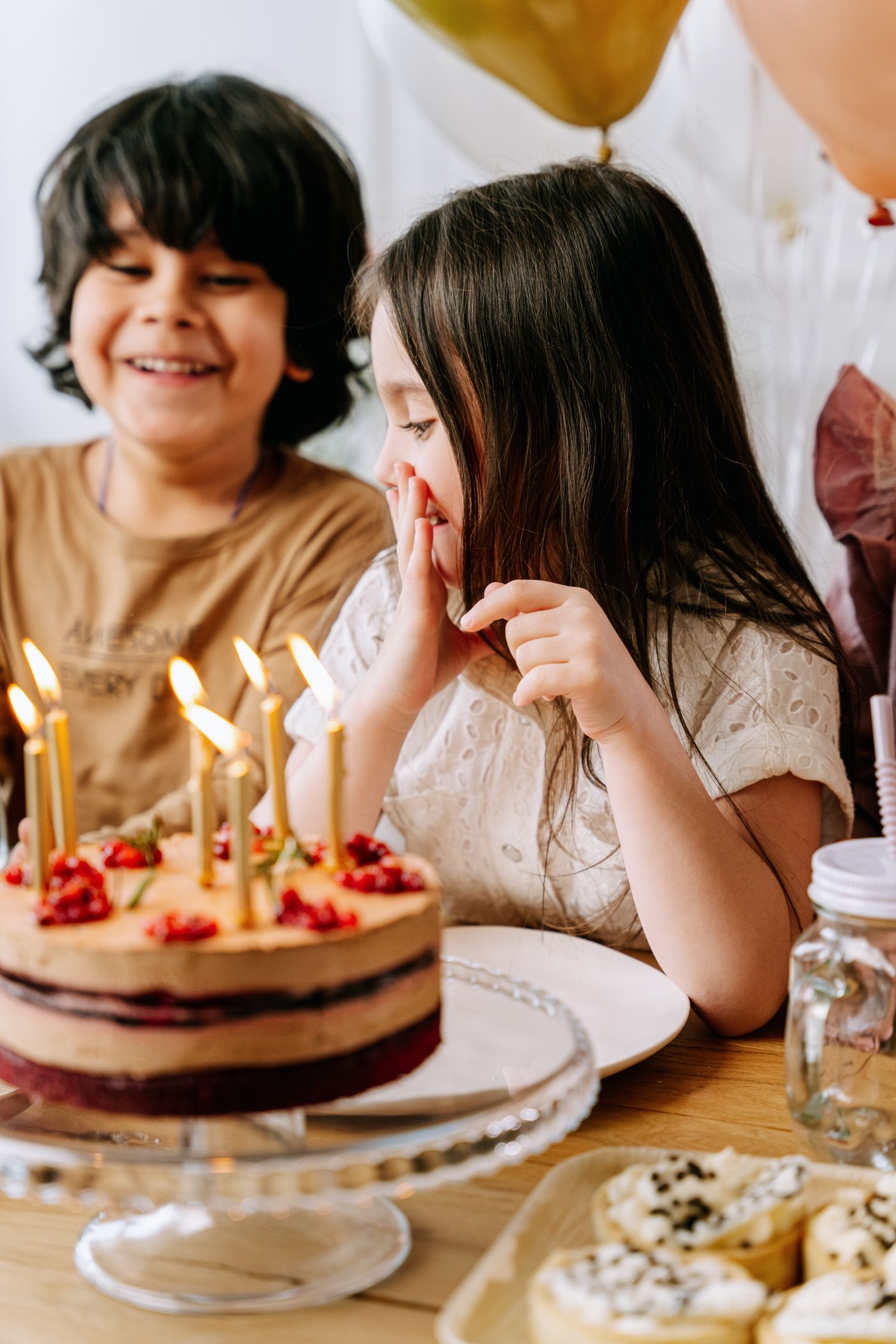 Kids gathered around a birthday cake with candles