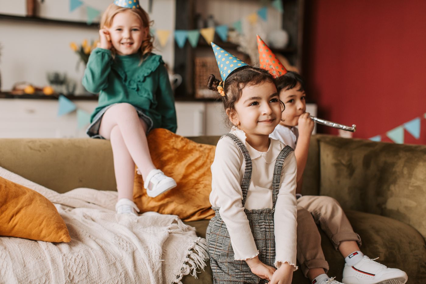 Three kids in party hats celebrating