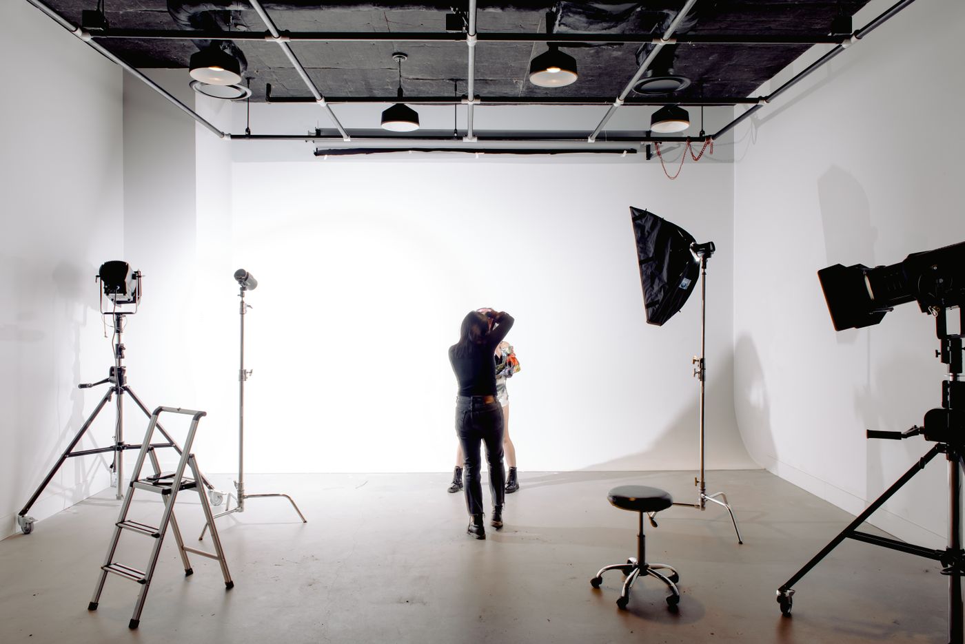 Photographer directing a model in a light studio