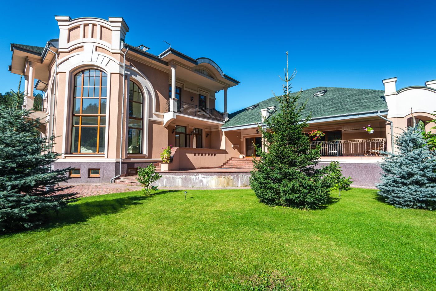 Modern villa with large windows and lawn